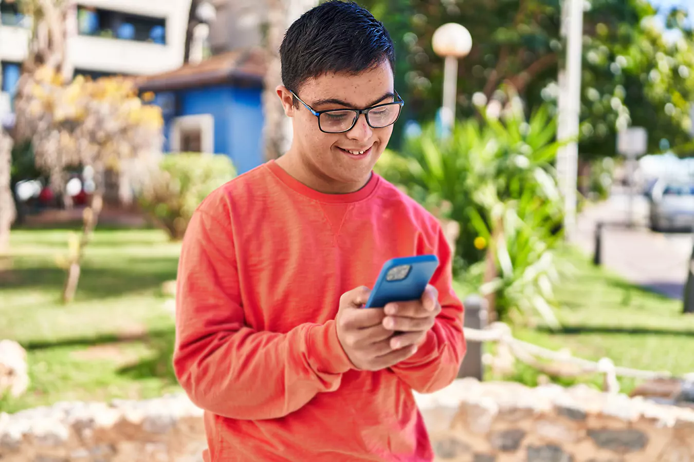A disabled man smiling while looking at his phone