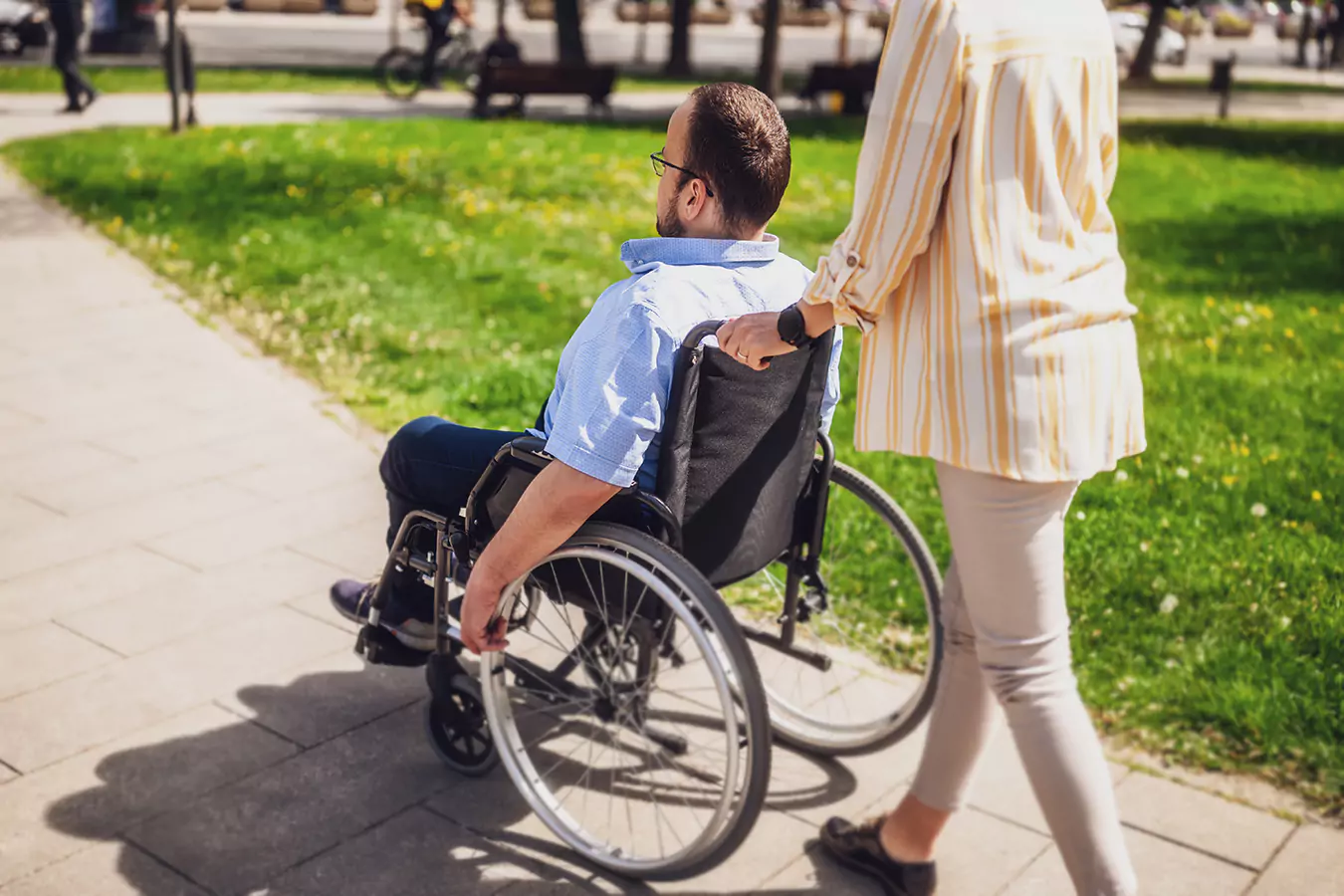A disabled man sitting in his wheelchair and his support worker